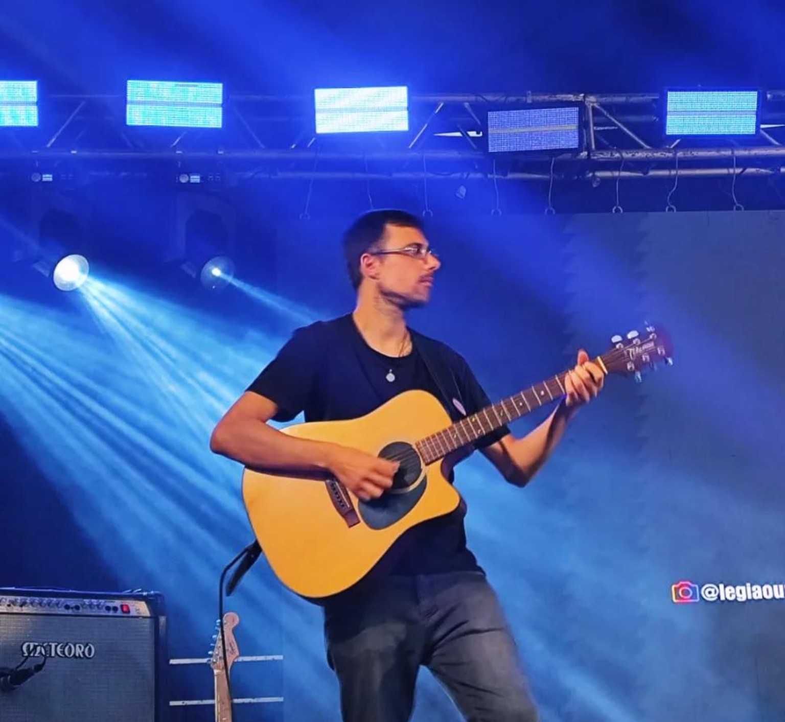 Fábio Bianchi tocando violão no palco